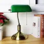 Antique bronze table lamp with green shade on bedside table