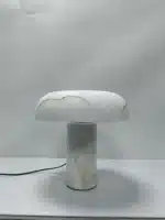 Elegant marble table lamp with soft glow on bedside table in bedroom