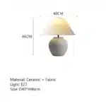 Wabi sabi table lamp with textured ceramic base and linen shade in a cozy living room