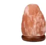 Salt lamp with color changing on wooden base glowing in warm light