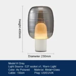 Modern table lamp with glass shade on bedside table