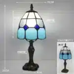 Tiffany table lamp with colorful stained glass shade casting warm glow on nightstand
