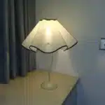 Elegant handmade petal lampshade casting a warm glow in a cozy bedroom