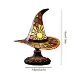 Witch hat lamp with stained glass pattern casting a warm glow on a bedside table