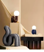 Modern glass table lamp with spherical shade on a wooden nightstand in a cozy bedroom