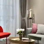 Modern floor lamp with iron frame and glass shade in a cozy living room