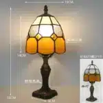 Tiffany table lamp with colorful stained glass shade casting warm glow on nightstand