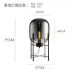 Modern floor lamp with iron frame and glass shade in a cozy living room