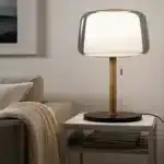 Modern bedside lamp with cream glass shade on a nightstand