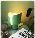 Rotating petal desk lamp with adjustable petals in pastel colors on a bedside table