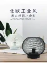 Decorative bird cage lamp with warm LED light, iron frame, and silk screen details on a bedside table