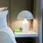 Modern mushroom table lamp with metal shade and wood base on bedside table