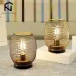 Battery table lamp with metal cage and warm LED glow on a wooden table