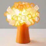 Modern table lamp with PVC flower design in a cozy bedroom setting