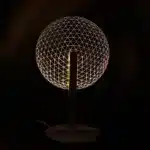 3D LED table lamp with wooden base and acrylic art glowing in a cozy room