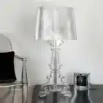 Modern acrylic table lamp glowing softly on a bedside table in a contemporary bedroom
