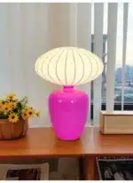 Vintage table lamp with retro ceramic base and silk shade on bedside table in cozy bedroom