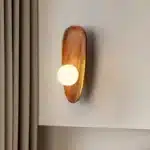 Vintage wall sconce with wooden backplate and clear glass shade, warm light