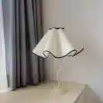 Elegant handmade petal lampshade casting a warm glow in a cozy bedroom