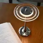 Goldoma rechargeable table lamp with flying saucer shape and warm glow on a bedside table