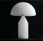 Elegant marble table lamp with soft glow on bedside table in bedroom