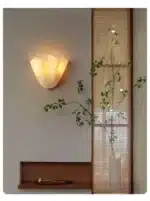 Modern wall sconce with shell-shaped glass and LED light in a minimalist living room