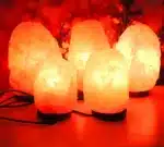 Salt lamp with color changing on wooden base glowing in warm light