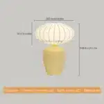Vintage table lamp with retro ceramic base and silk shade on bedside table in cozy bedroom