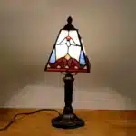 Vintage table lamp with handmade colored glass shade casting warm ambient light