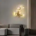 Luxury gold leaf sconce with modern ginkgo design illuminating a living room wall
