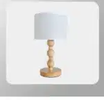 Vintage table lamp with fabric shade and solid wood base on bedside table