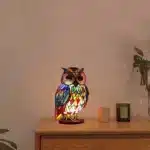 Colorful stained glass animal lamp featuring a cat design, glowing warmly on a bedside table