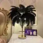 Ostrich feather table lamp glowing warmly on a bedside table in a cozy bedroom