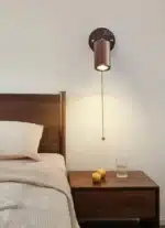 Walnut bedside wall light with adjustable spotlight and zipper switch in a cozy bedroom