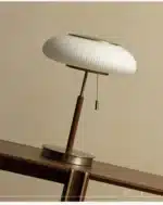 White glass table lamp with vintage design on a wooden desk in a cozy bedroom