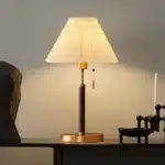 Retro desk lamp with black metal base and pleated fabric shade in warm glow