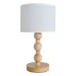 Vintage table lamp with fabric shade and solid wood base on bedside table