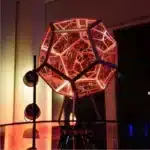 Dodecahedron gaming light with vibrant RGBW colors illuminating a gaming desk setup