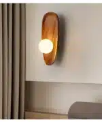 Vintage wall sconce with wooden backplate and clear glass shade, warm light