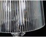 Modern acrylic table lamp glowing softly on a bedside table in a contemporary bedroom