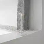 Modern rechargeable table lamp glowing warmly on a wooden bedside table