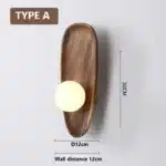 Vintage wall sconce with wooden backplate and clear glass shade, warm light