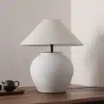 Wabi sabi table lamp with textured ceramic base and linen shade in a cozy living room