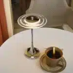 Goldoma rechargeable table lamp with flying saucer shape and warm glow on a bedside table
