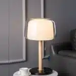 Modern bedside lamp with cream glass shade on a nightstand