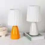 Milkshake bedside table lamp with warm LED light on a nightstand in a cozy bedroom