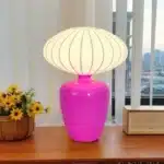Vintage table lamp with retro ceramic base and silk shade on bedside table in cozy bedroom