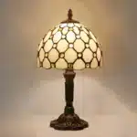 Vintage table lamp with handmade colored glass shade casting warm ambient light