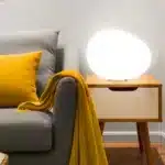 Warm night light pebble LED lamp glowing on a bedside table