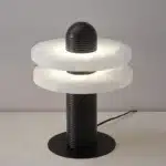 Elegant marble table lamp with soft glow on bedside table in bedroom